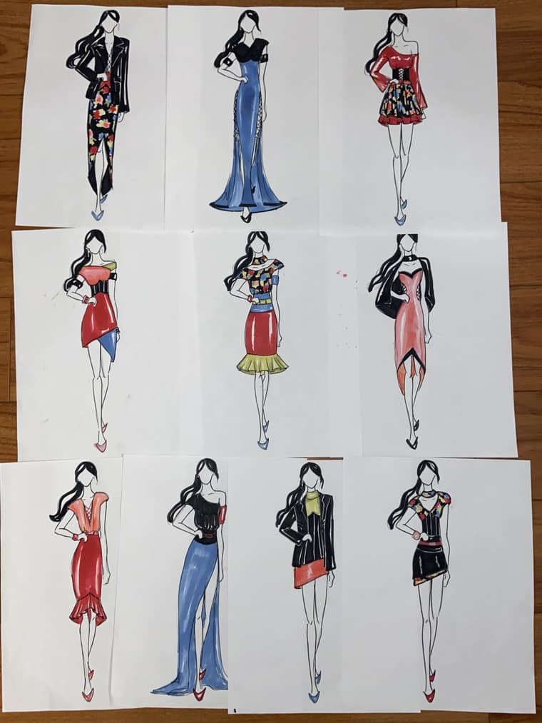 Ten fashion croquis sheets laid out on a wooden floor, a collection of dresses in red, blue, and black